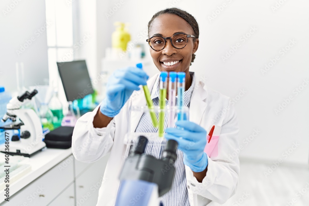 African american woman scientist holding test tubes at laboratory African american woman scientist holding test tubes at laboratory