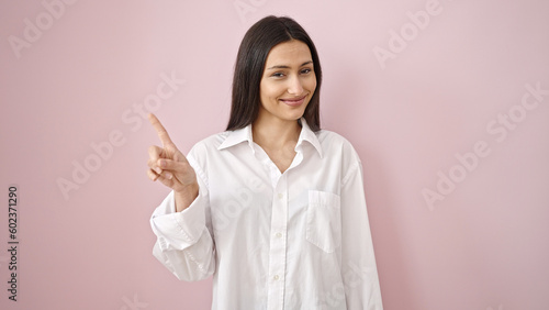 Foto Young beautiful hispanic woman smiling confident saying no with finger over isol