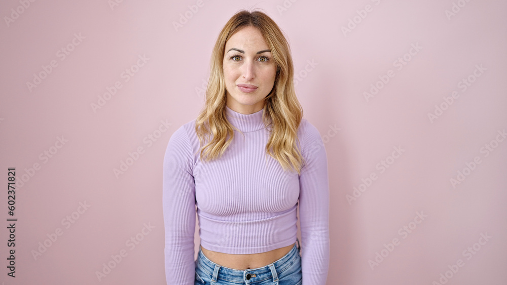 Young beautiful hispanic woman standing with serious expression over isolated pink background Young beautiful hispanic woman standing with serious expression over isolated pink background