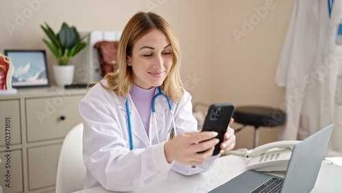 Young beautiful hispanic woman doctor using smartphone working at clinic