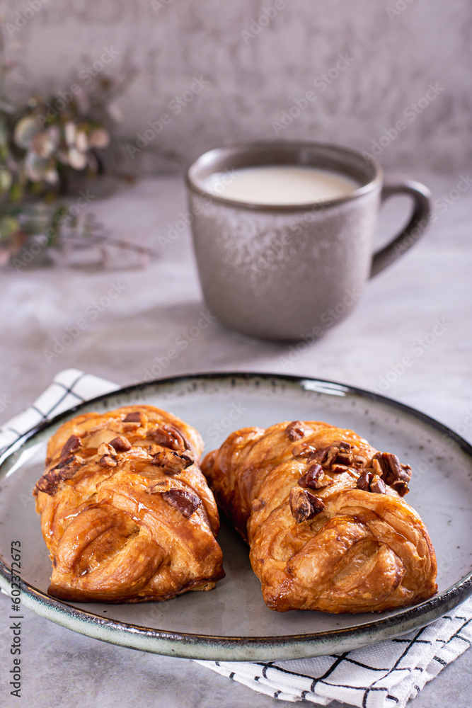 Wicker buns with cinnamon, nuts and maple syrup and a cup of coffee for Swedish fika time vertical Wicker buns with cinnamon, nuts and maple syrup and a cup of coffee for Swedish fika time vertical