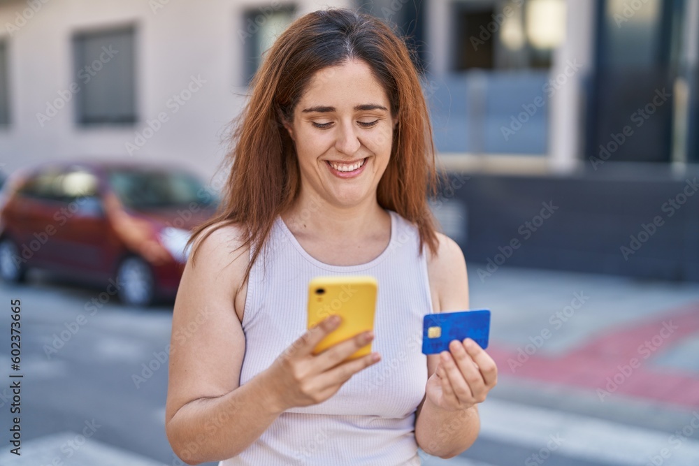 Young woman using smartphone and credit card at street Young woman using smartphone and credit card at street
