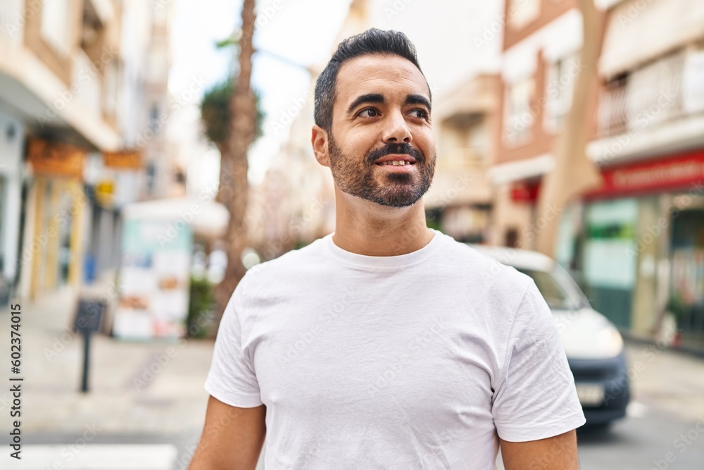 Fototapeta premium Young hispanic man smiling confident standing at street