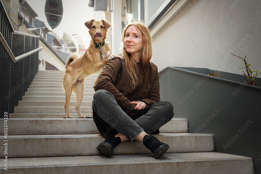 Beautiful blonde girl with dog in the city