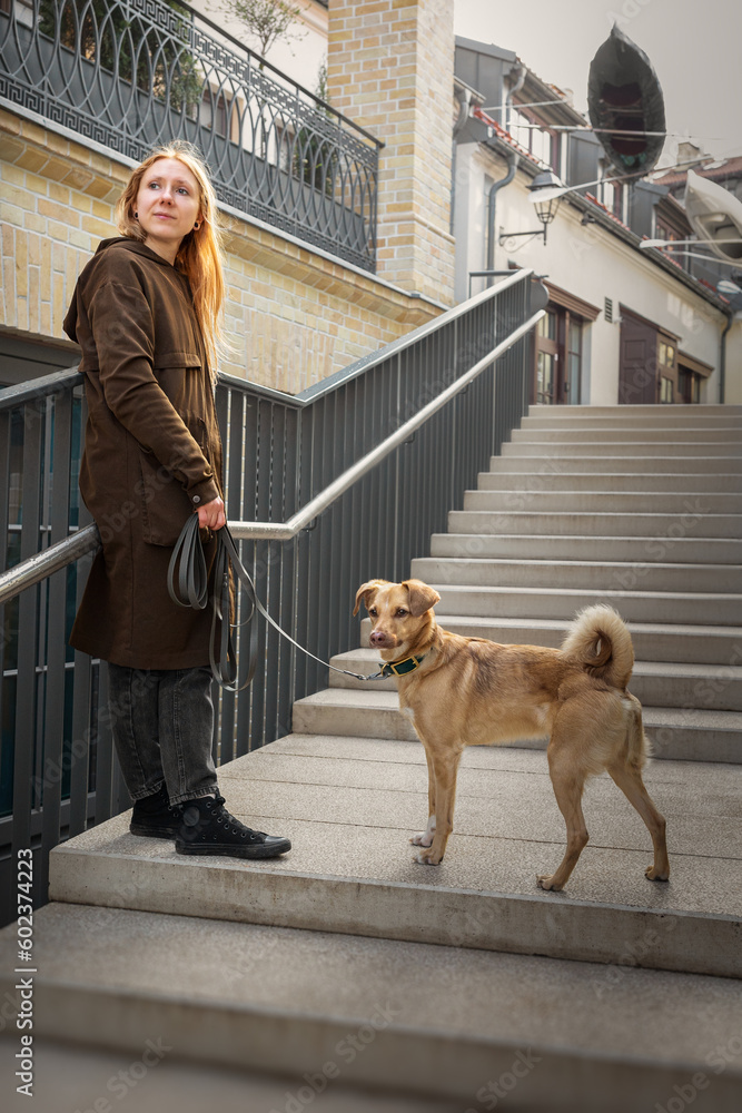 Beautiful blonde girl with dog in the city