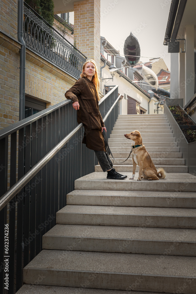 Beautiful blonde girl with dog in the city