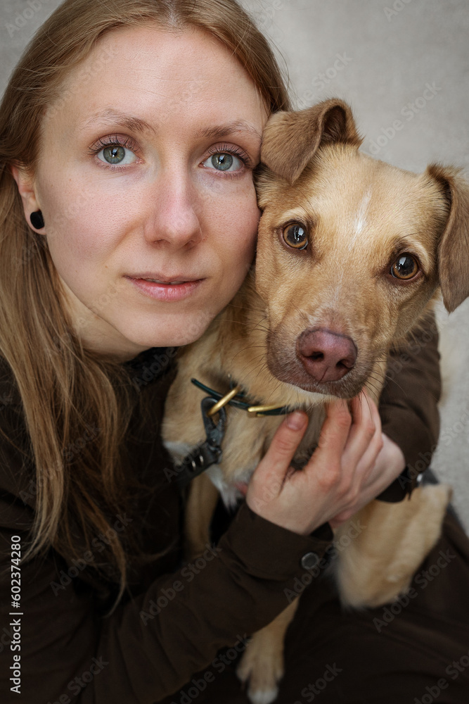 Portrait of beautiful blonde girl with a dog