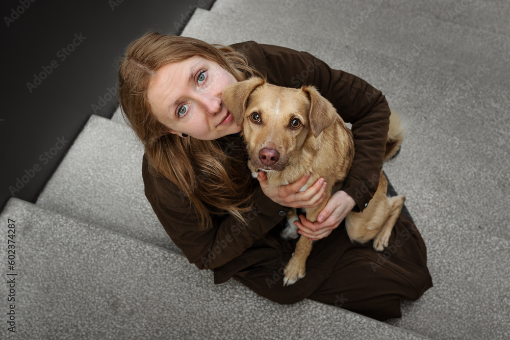 Portrait of beautiful blonde girl with a dog