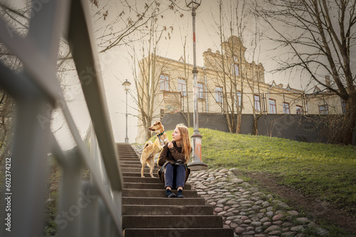 Beautiful blonde girl with dog in the city