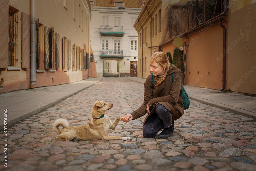 Beautiful blonde girl with dog in the city