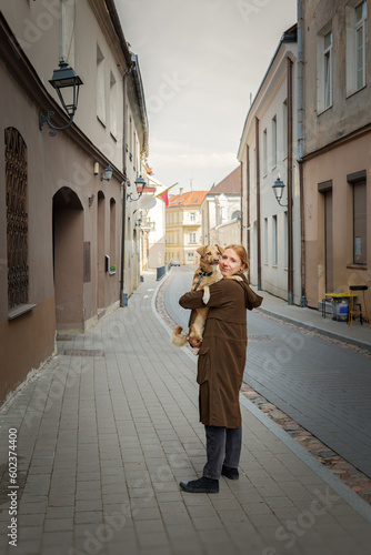 Beautiful blonde girl with dog in the city