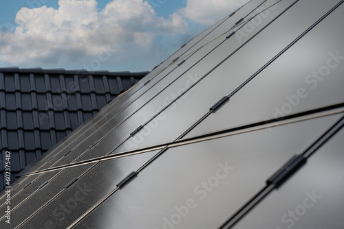 Diese PV-Anlage auf dem Dach einer modernen Wohnanlage nutzt die Kraft der Sonne, um erneuerbare Energie zu erzeugen. Die Solarpanels fangen das Sonnenlicht ein und wandeln es in saubere, grüne Energi