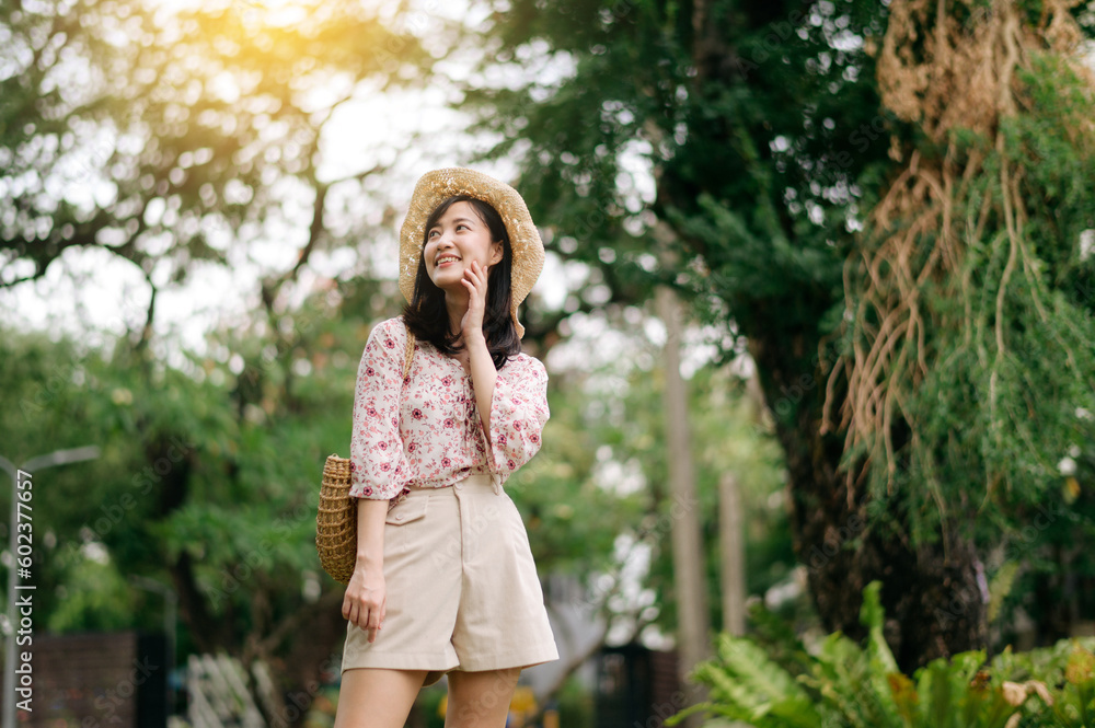 Portrait of asian young woman traveler with weaving hat and basket happy smile on green public park nature background. Journey trip lifestyle, world travel explorer or Asia summer tourism concept. Portrait of asian young woman traveler with weaving hat and basket happy smile on green public park nature background. Journey trip lifestyle, world travel explorer or Asia summer tourism concept.