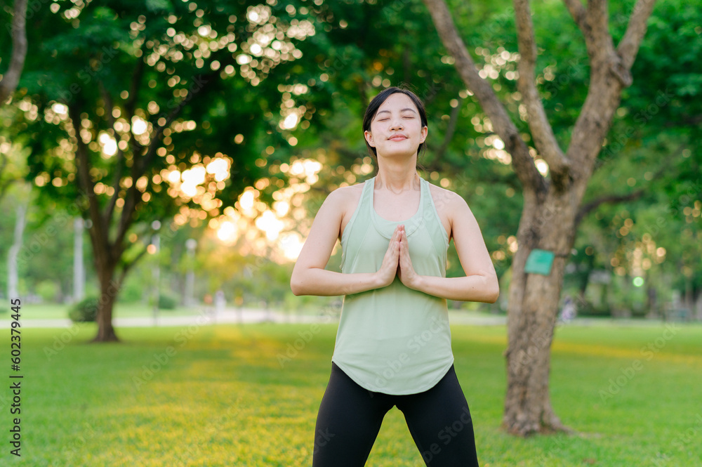 Female jogger. Fit young Asian woman with green sportswear breathing fresh air in park before running and enjoying a healthy outdoor. Fitness runner girl in public park. Wellness being concept Female jogger. Fit young Asian woman with green sportswear breathing fresh air in park before running and enjoying a healthy outdoor. Fitness runner girl in public park. Wellness being concept