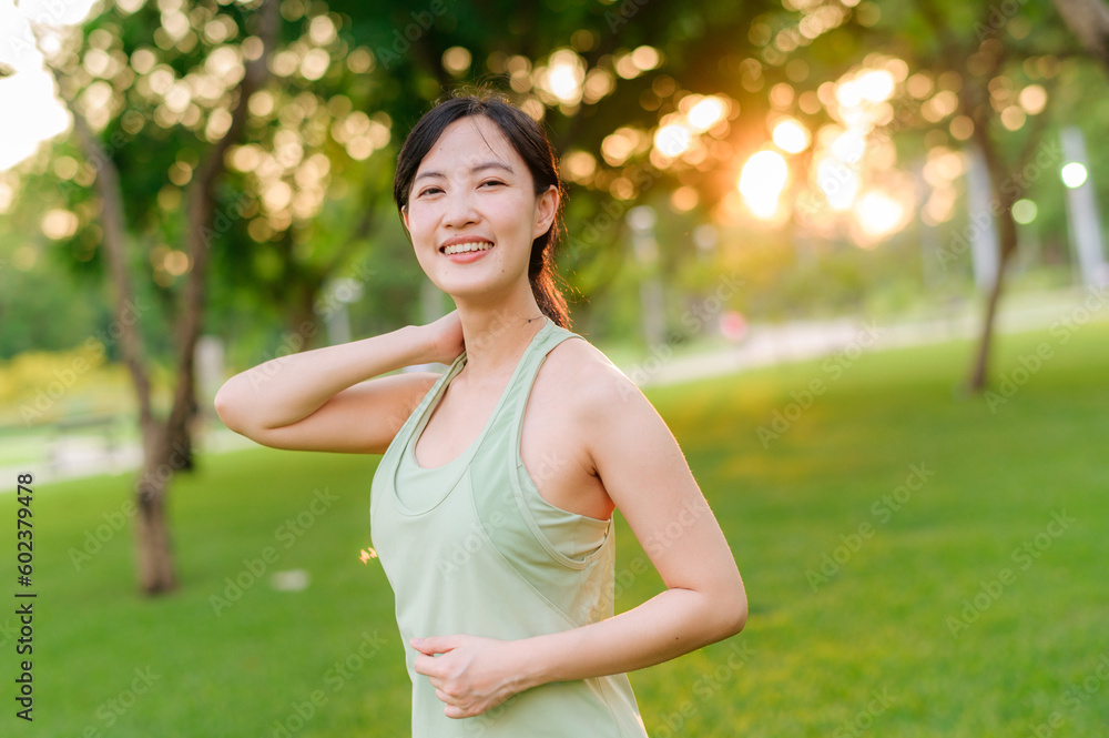 Female jogger. Fit young Asian woman with green sportswear stretching muscle in park before running and enjoying a healthy outdoor. Fitness runner girl in public park. Wellness being concept Female jogger. Fit young Asian woman with green sportswear stretching muscle in park before running and enjoying a healthy outdoor. Fitness runner girl in public park. Wellness being concept