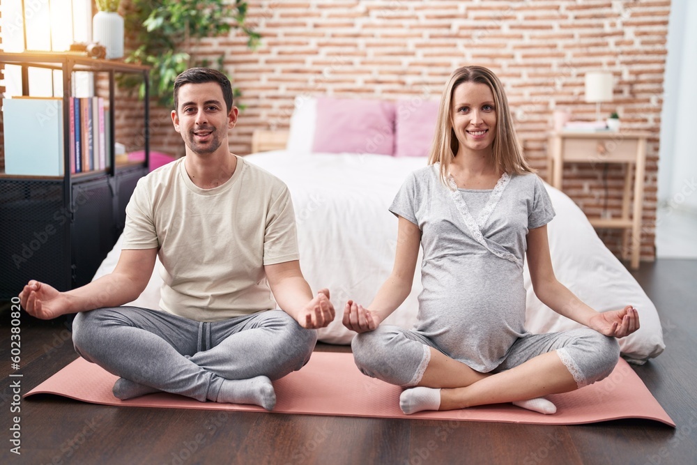 Man and woman couple expecting belly doing yoga exercise at bedroom Man and woman couple expecting belly doing yoga exercise at bedroom