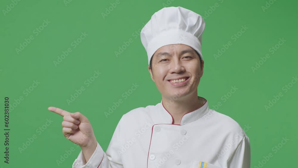 Close Up Of Asian Man Chef Smiling And Pointing To Side While Standing In The Green Screen Background Studio
Close Up Of Asian Man Chef Smiling And Pointing To Side While Standing In The Green Screen Background Studio
