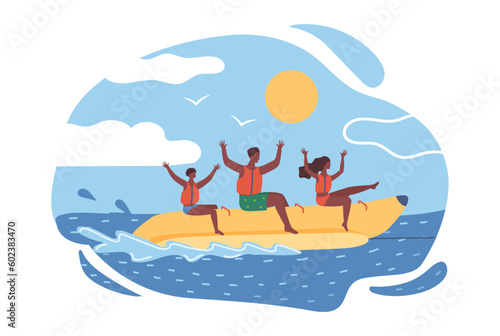 An African American family rides on a banana at the sea. Summer fun, father, mother and son enjoy life.