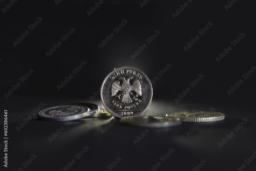 Selective blur on a one ruble coin with the mention one ruble and bank of russia written in russian, isolated on a black background. RUB, or russian ruble, is the official currency and money of Russia