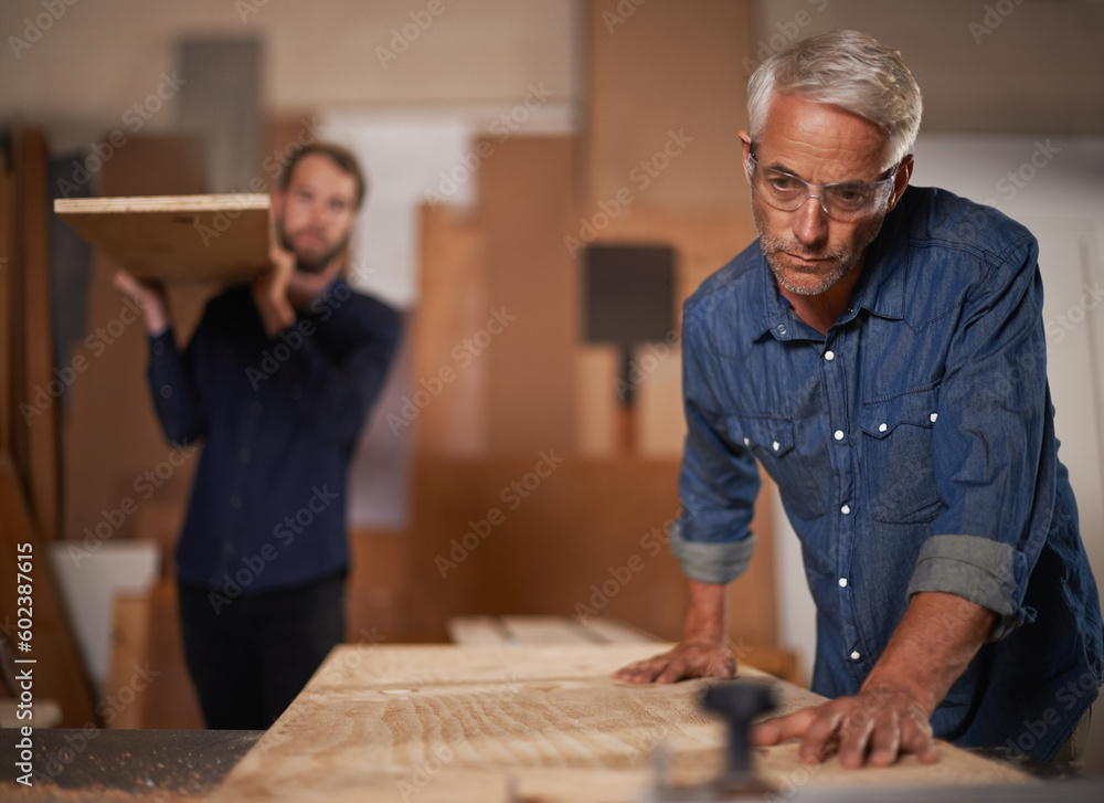 Carpenter team, men in collaboration and work in workshop on design project with vocation and creative DIY skill. Teamwork, carpentry and male employee saw wood with father and son working together Carpenter team, men in collaboration and work in workshop on design project with vocation and creative DIY skill. Teamwork, carpentry and male employee saw wood with father and son working together