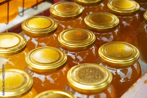 Jars full with different types of fresh organic honey outdoors in farmer market. View from above. Healthy food