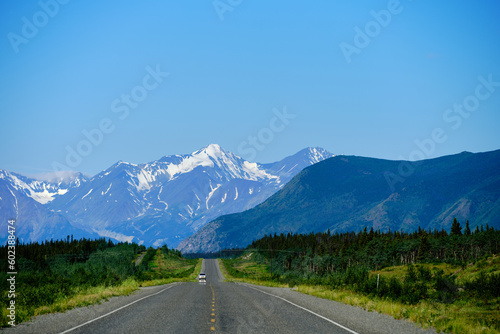 The paved portion of the Alaska Highway and snow covered mountains in the Yukon Territory