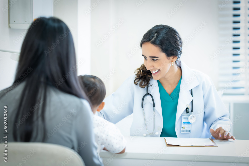Pediatrician giving advice to mother of sick little girl at hospital. Pediatrician giving advice to mother of sick little girl at hospital.