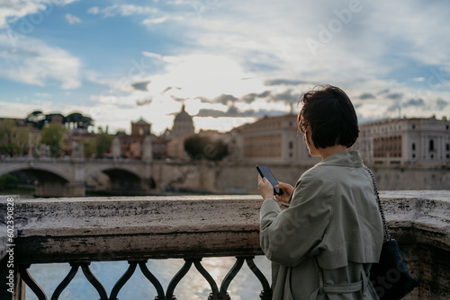 Canvas Print Beautiful young happy female with sunglasses using mobile phone in Rome Italy
