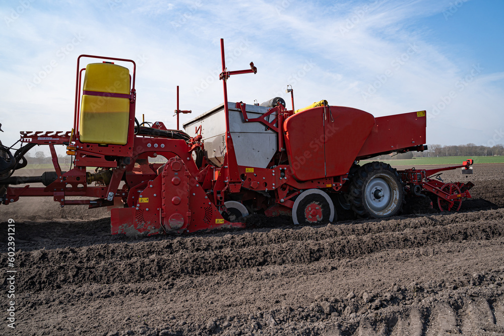 Obraz premium Kartoffelbestellung - Rote Kartoffellegemaschine beim legen von Saatkartoffeln - Seitenansicht