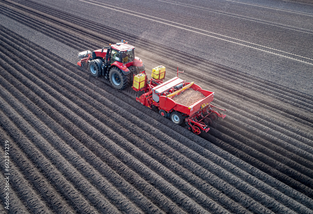 Moderne Landtechnik wird eingesetzt beim legen der Saatkartoffeln - Luftbild - Traktor mit Kartoffellegemaschine.