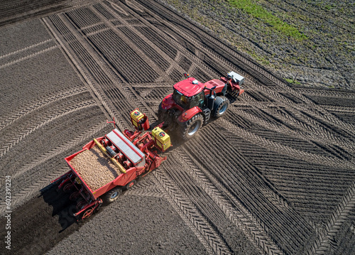 Traktor am wenden, mit einer Kartoffellegemaschine gefüllt mit Saatkartoffeln, auf einem Feld -  Luftbild photo