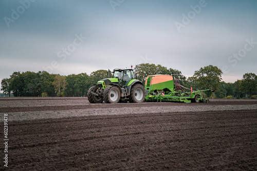  Landwirt mit moderner Landtechnik bei der Aussaat von Winterraps - vor dramatischen Himmel. photo