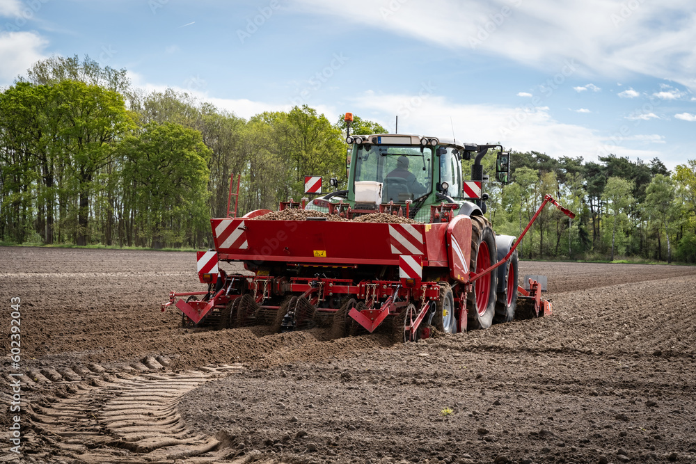 Moderne Landtechnik für die Bestellung des Katoffelackers im Einsatz - Traktor mit Kartoffellegemaschine. Moderne Landtechnik für die Bestellung des Katoffelackers im Einsatz - Traktor mit Kartoffellegemaschine.