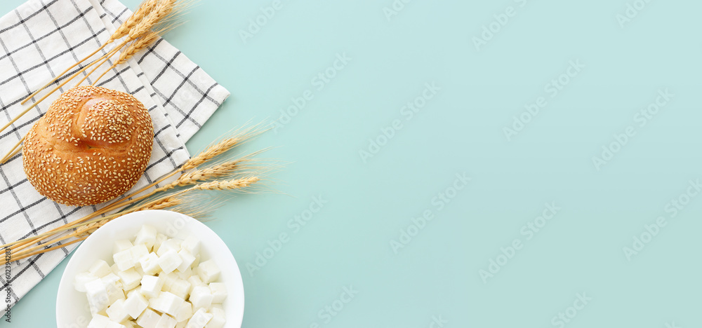 Photo of bread and dairy product over mint background. Symbols of jewish holiday - Shavuot