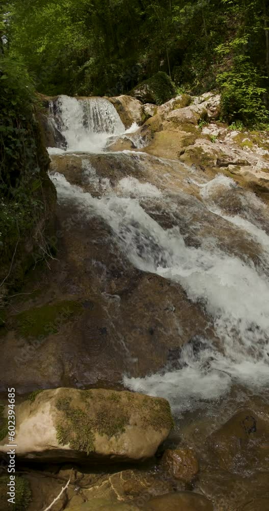 Beautiful waterfalls on sunny stream river in slow motion. Vertical shot. Beautiful waterfalls on sunny stream river in slow motion. Vertical shot.