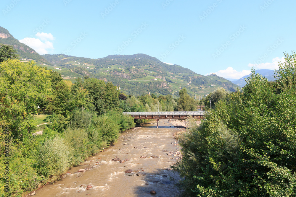 Wooden bridge over the river Talfer with mountain panorama in Bolzano, South Tyrol, Italy