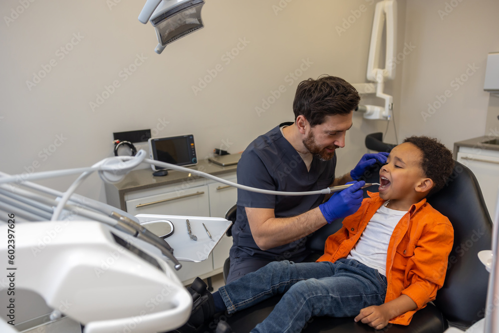 Obraz premium Male dentist working with dark-skinned boy