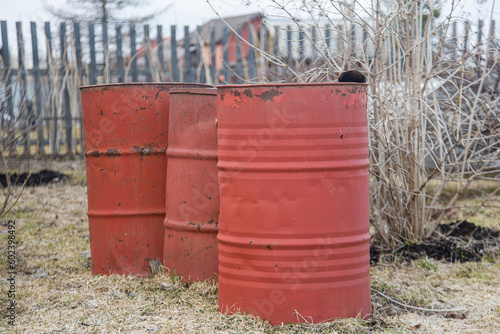 red metal barrels on the garden plot