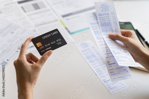 Financial owe, hand of asian woman sitting, holding credit card, stressed  by calculate expense from invoice or bill, no money to pay, mortgage or loan. Debt, bankruptcy or bankrupt.