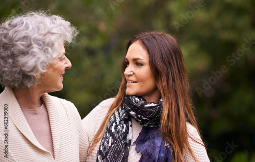 Talking, outdoor and woman with elderly mother together on a nature vacation or holiday bonding in happiness. Retirement, women and young happy female person in conversation and with mom in a garden