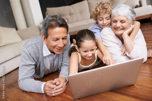 Laptop, floor or grandparents with happy kids for movie streaming online subscription in retirement at home. Children siblings, relax or grandmother watching videos on internet with a senior old man