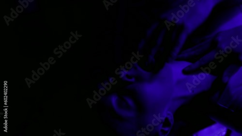 desire and passion during erotic dance show and caress, face of adult woman in darkness with laser
