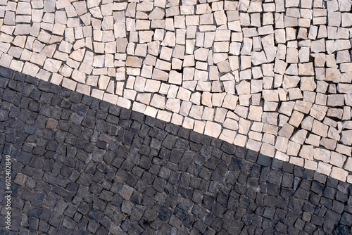 Portuguese traditional black and white pavement made from calcada tiling. Fragment of sidewalk paving in Funchal, Madeira island