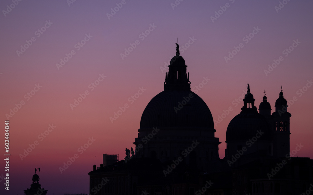 Salute Church Venice Italy. Silhouette of the cathedral domes at sunrise, purple sky and vibrant colours on this famous venetian landmark