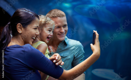 Aquarium, happy and family selfie by fish on vacation, holiday and trip together. Photo, fishtank and father, mother and girl taking pictures for memory, social media or profile picture in oceanarium