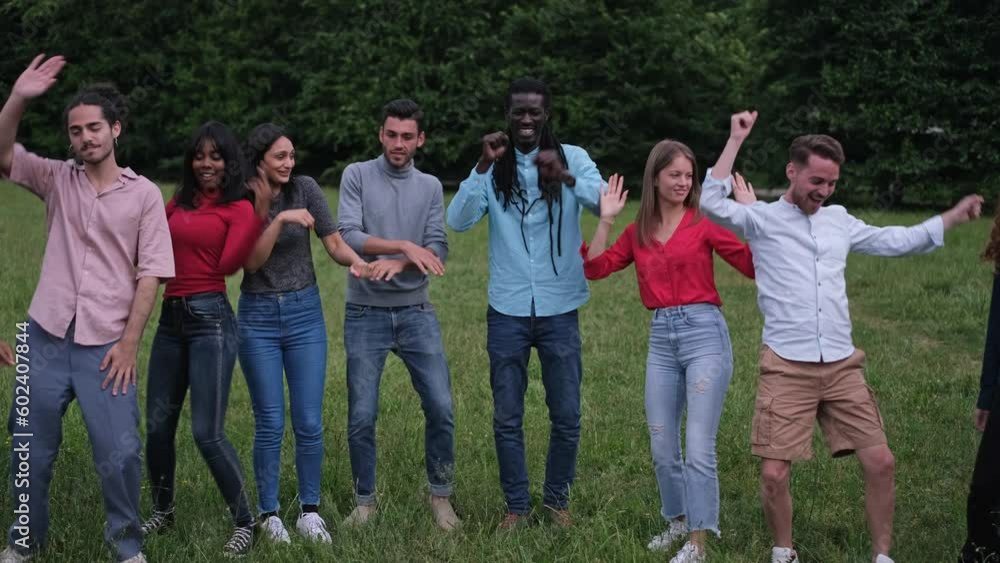 Young people from different cultures dancing outdoors in the park. Concept: lifestyle, dance, together Young people from different cultures dancing outdoors in the park. Concept: lifestyle, dance, together