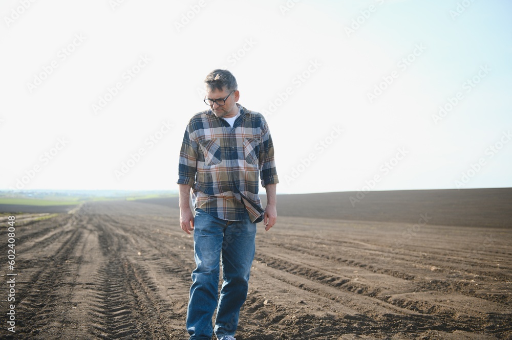 A farmer checks quality of soil before sowing.