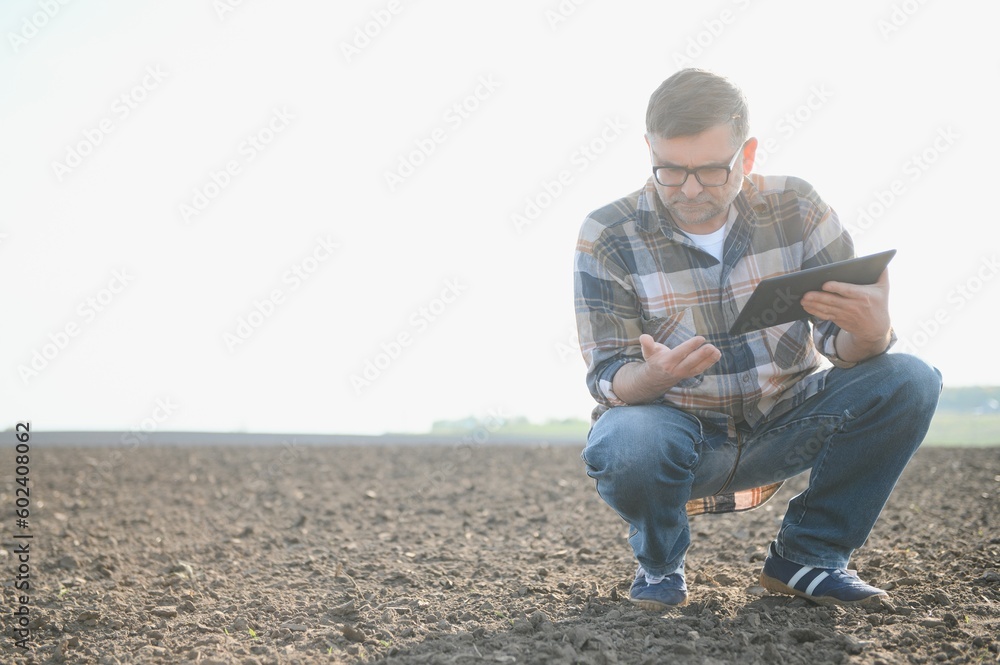 A farmer checks quality of soil before sowing.
