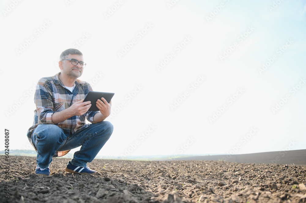A farmer works in a field sown in spring. An agronomist walks the earth, assessing a plowed field in autumn. Agriculture. Smart farming technologies. A farmer works in a field sown in spring. An agronomist walks the earth, assessing a plowed field in autumn. Agriculture. Smart farming technologies.