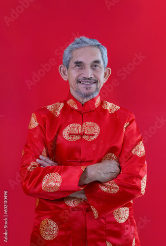 portrait asian senior man with grey hair and beard in traditional chinese clothes isolated on red background